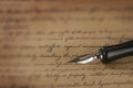 A vintage pen on a handwritten paper
