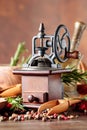 Vintage pepper mill with kitchen utensils  spices and rosemary on a old wooden table Royalty Free Stock Photo