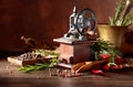 Vintage pepper mill with kitchen utensils, spices and rosemary on a old wooden table