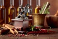 Old pepper mill with cooking utensils, bottles of olive oil, spices and rosemary on a wooden table Royalty Free Stock Photo