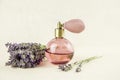 Vintage perfume bottle with lavender aroma. Lavender calming aroma scent concept on light beige background with fresh lavender.