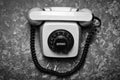 Vintage phone with a rotational dial on a concrete surface. Royalty Free Stock Photo