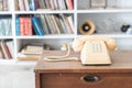 Vintage phone on wooden table, on bookshelf background Royalty Free Stock Photo