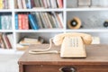 Vintage phone on wooden table, on bookshelf background Royalty Free Stock Photo