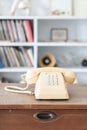 Vintage phone on wooden table, on bookshelf background Royalty Free Stock Photo