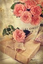 Vintage photo of a bunch of roses and a gift in romantic style Royalty Free Stock Photo
