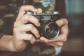 Vintage photo camera in the hands of man, soft focus. Royalty Free Stock Photo