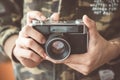 Vintage photo camera in the hands of man, soft focus. Royalty Free Stock Photo