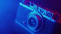 Vintage photo camera in neon blue light, smooth cinematic motion, filmic haze