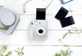Vintage photo camera on white background with photo cards. Polaroid camera. Instax white camera. Flat lay. Royalty Free Stock Photo