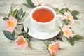 Vintage photo, Cup of tea and wild rose flower on old rustic wooden background Royalty Free Stock Photo