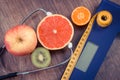 Vintage photo, Electronic bathroom scale, centimeter and fresh fruits with stethoscope, slimming and healthy lifestyles Royalty Free Stock Photo