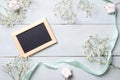 Vintage photo frame with flowers on light blue wooden background. Banner mockup for congratulation with womans or mother day, wedd