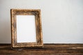 Vintage photo frame on old wooden table over white wall background Royalty Free Stock Photo