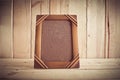 Vintage photo frame on wooden table over wood background Royalty Free Stock Photo