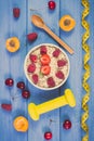 Vintage photo, Fresh prepared oatmeal with fruits, centimeter and dumbbells, healthy lifestyle and nutrition Royalty Free Stock Photo