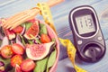 Vintage photo, Fruit and vegetable salad and glucometer with tape measure, concept of diabetes, slimming and healthy nutrition Royalty Free Stock Photo