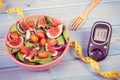 Vintage photo, Fruit and vegetable salad and glucometer with tape measure, concept of diabetes, slimming and healthy nutrition Royalty Free Stock Photo