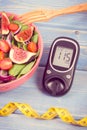 Vintage photo, Fruit and vegetable salad and glucometer with tape measure, concept of diabetes, slimming and healthy nutrition Royalty Free Stock Photo