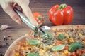 Vintage photo, Hand cutting vegetarian pizza, ingredients with spices on wooden background Royalty Free Stock Photo