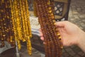 Vintage photo, Hand of woman with shiny womanly amber necklaces on stall at bazaar