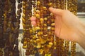 Vintage photo, Hand of woman with shiny womanly amber necklaces on stall
