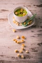 Vintage photo of pea soup with croutons spilled on wooden board Royalty Free Stock Photo