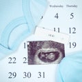 Vintage photo, Pregnancy test, ultrasound scan of baby and clothing for newborn on calendar, expecting for baby Royalty Free Stock Photo