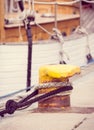 Vintage photo, Detail of yachting, Rope with old mooring bollard and yacht in background Royalty Free Stock Photo