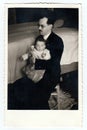 A vintage photo shows father with baby girl, circa 1940
