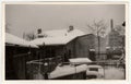 Vintage photo shows the house and the backyard in winter time. Retro black and white photography. Circa 1950s