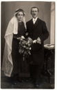 Vintage photo shows newlyweds. The bride wears long white veil. Retro black and white studio photography of married Royalty Free Stock Photo