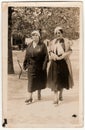 Vintage photo shows women go for a walk in the city park. Original retro black and white photography