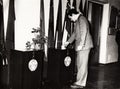 A vintage photo shows a young man putting his ballot into a ballot box at a polling station