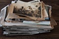 Vintage photo stack, old family photos on a dark wooden background.