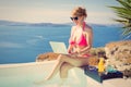Vintage photo of woman in bikini and laptop in hands