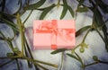Vintage photo, Wrapped pink gift for Christmas and mistletoe on old wooden background