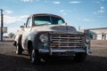 Vintage pickup truck parked along a dirt road.