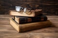 vintage pile of five old brown leather books with eye glasses on a wood table3