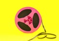 Vintage pink audio reel with recording tape on yellow paper background. Trendy pop art style. Royalty Free Stock Photo