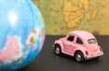Vintage pink car and globe on map background, travel concept Royalty Free Stock Photo