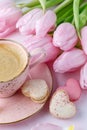 Vintage pink coffee cup, tulip flowers and french sweet cookies macarons macaroons on marble background Royalty Free Stock Photo