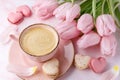 Vintage pink coffee cup, tulip flowers and french sweet cookies macarons macaroons  on marble background Royalty Free Stock Photo