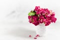 Vintage pink dry tiny roses in white wicker basket in airy soft light white interior with sunbeams, closeup, copy space, blur.