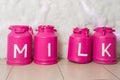 Vintage pink storage containers milk on white background. Metal milk churns stand in row Royalty Free Stock Photo