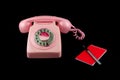 Vintage Pink Telephone with Pen and Notebook on a Black Background Royalty Free Stock Photo