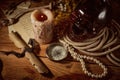 Pirate still life with candle, compass, dark rum in a skull bottle and old papers