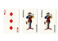 Vintage playing cards showing a pair of jokers and a three.