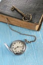 Vintage pocket watch, old book and a brass key