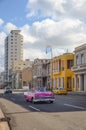 Vintage pontiac pink convertible car driving in the Malecon in La havana city.